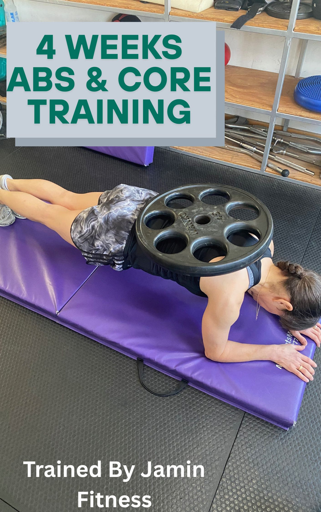 Advanced core training demonstration showing plank position with weight plate on lower back, performed on purple exercise mat at Jamin Fitness, highlighting proper form for 4-week abs program